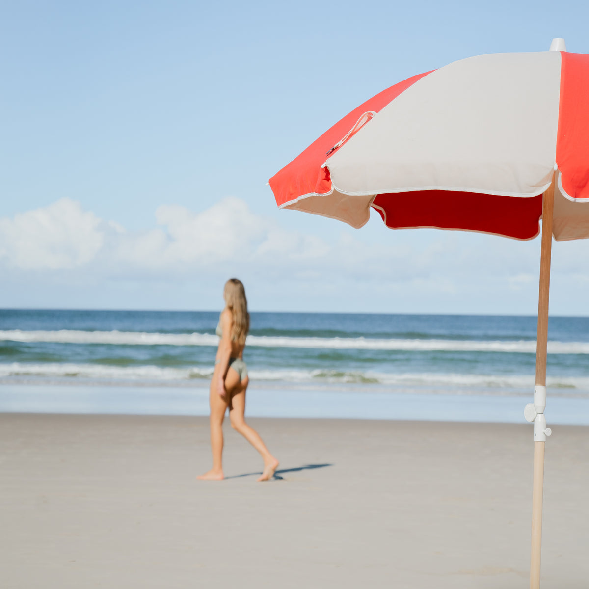 Rio Splice Beach Umbrella in the foreground of a beach walk