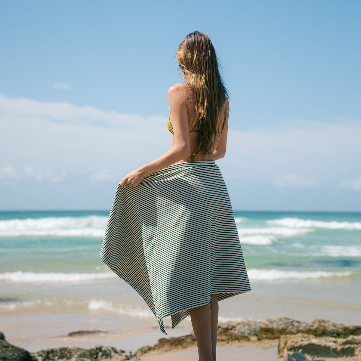Native striped beach towel wrapped around a model at the beach.